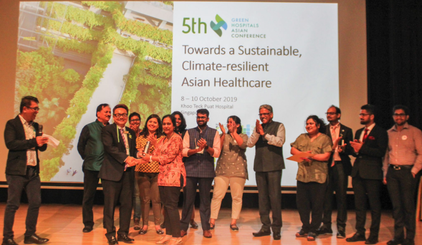 5th Green Hospitals Asian Conference attendees standing and applauding on the prize delivered to a woman
