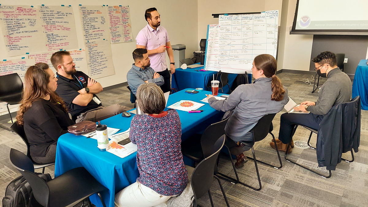 Participants from state, local, tribal and territorial governments as well as other community-based organizations work together on a simulated heat response scenario at the Las Vegas Tabletop Exercise in December 2022. (Image credit: NOAA)